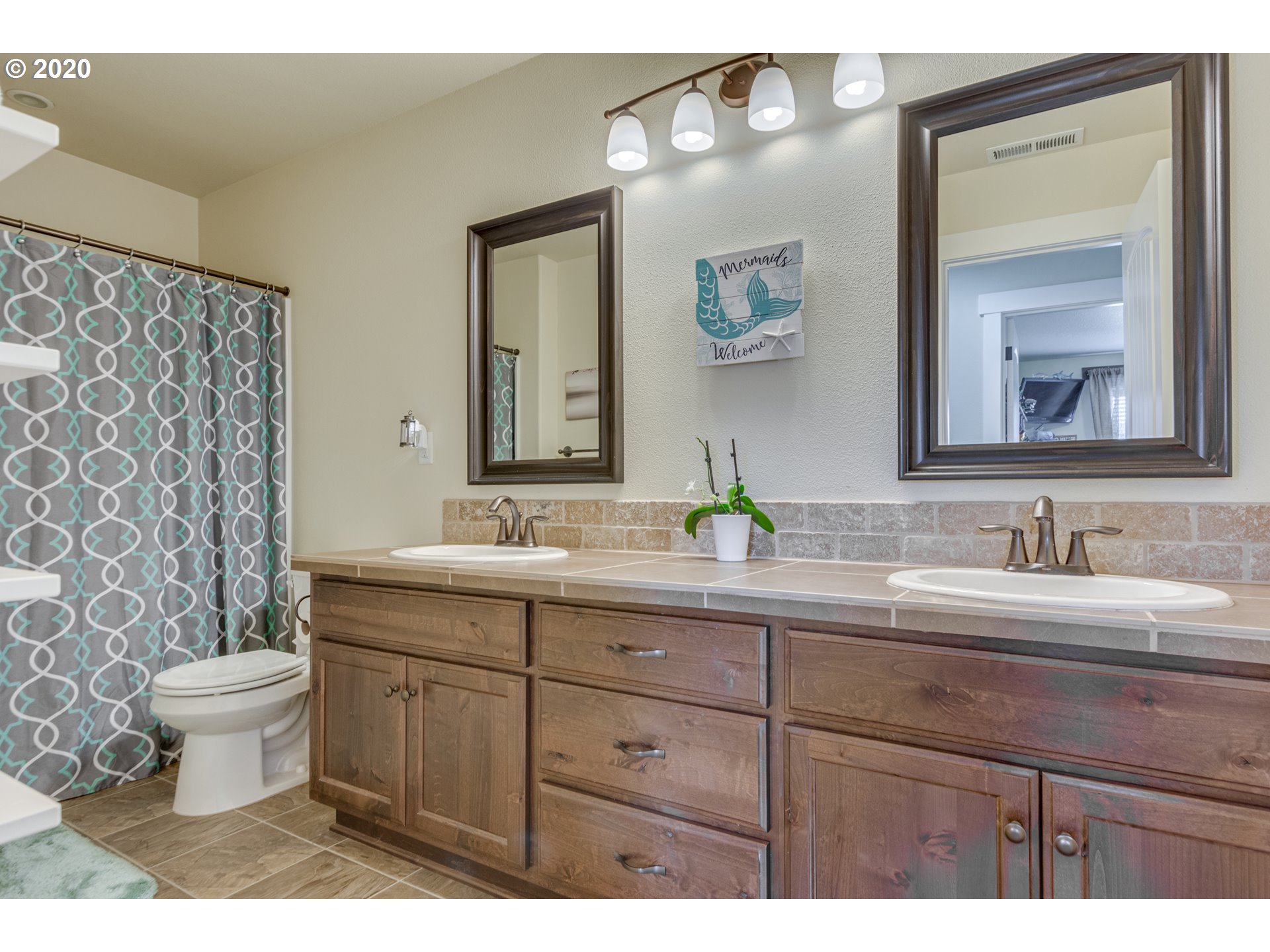 4009 North 5th Way Ridgefield, WA 98642 - Photo 20 of 32 a bathroom with a toilet sink double vanity and mirror