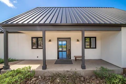 a living room with furniture a flat screen tv and kitchen view