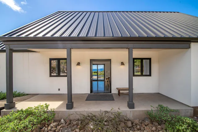 a living room with furniture a flat screen tv and kitchen view