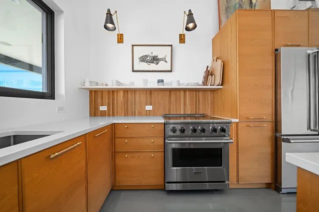 a kitchen with stainless steel appliances refrigerator dining table and chairs