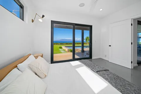 a bedroom with a bed and a large window