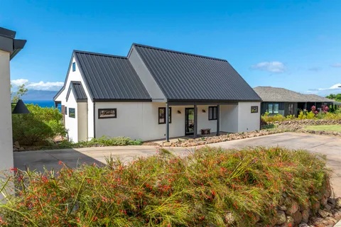 a front view of a house with a garden