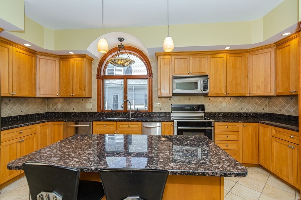 31 Morris Street Everett, MA 02149 - Photo 23 of 42 a kitchen with stainless steel appliances granite countertop a stove a sink and a microwave