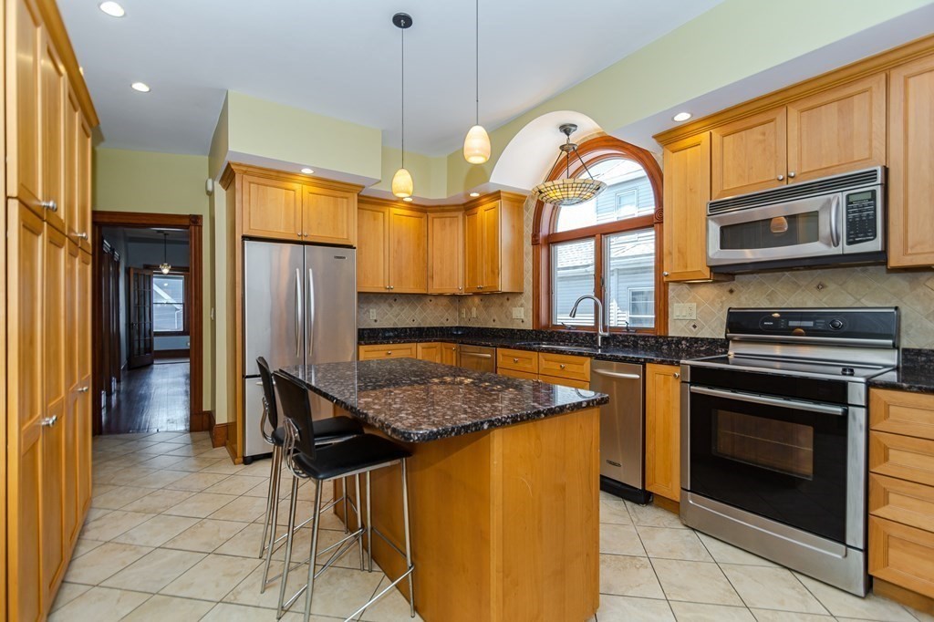 31 Morris Street Everett, MA 02149 - Photo 25 of 42 a kitchen with stainless steel appliances granite countertop a stove a refrigerator and a microwave
