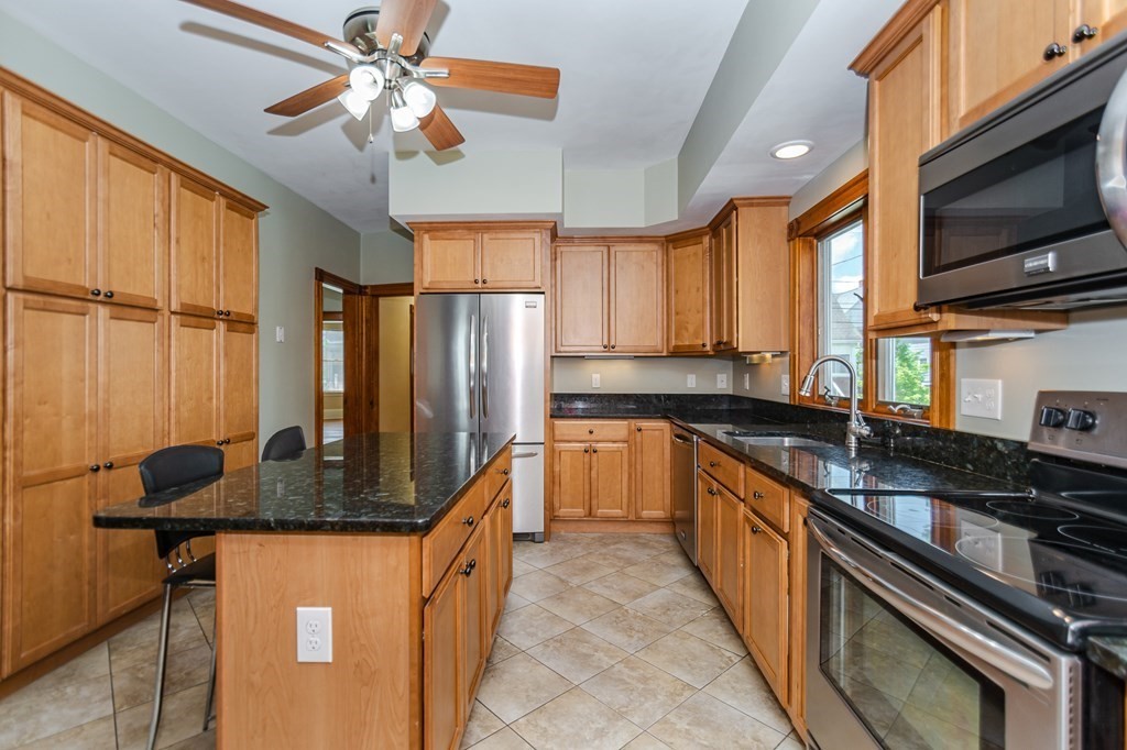 31 Morris Street Everett, MA 02149 - Photo 9 of 42 a kitchen with stainless steel appliances granite countertop a sink a stove and a refrigerator