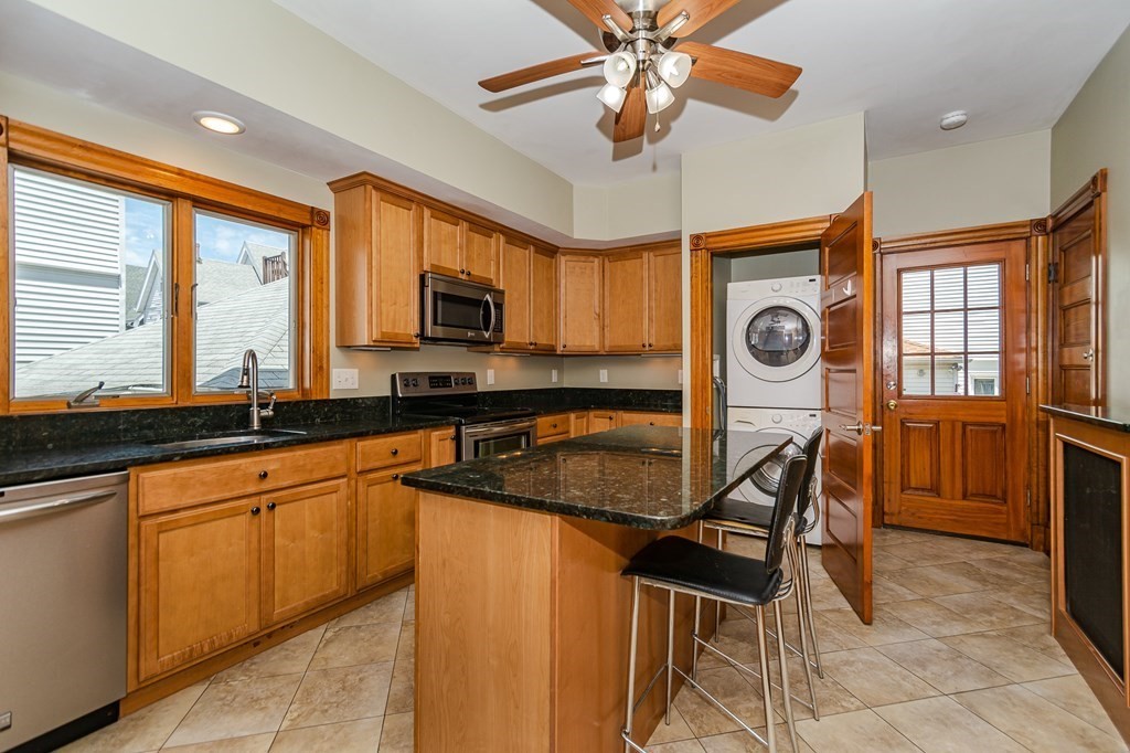 31 Morris Street Everett, MA 02149 - Photo 10 of 42 a kitchen with stainless steel appliances granite countertop a stove top oven a sink a dining table and chairs