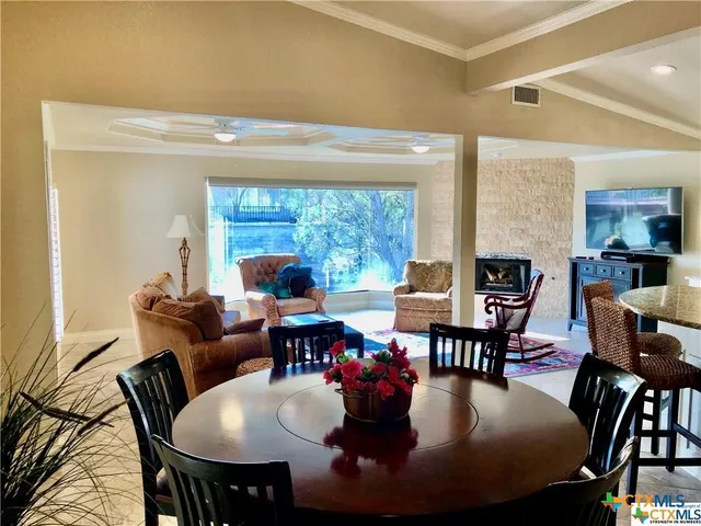 a dining room with furniture a large window and a chandelier