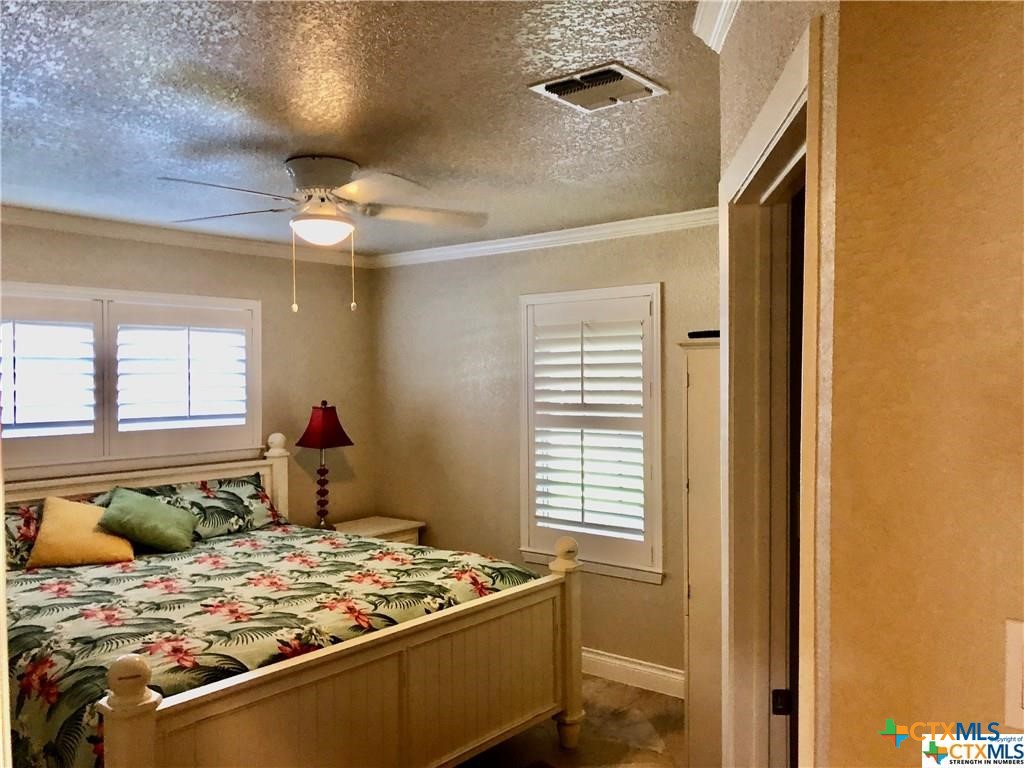 156 Trelawney Street McQueeney, TX 78123 - Photo 7 of 13 a bedroom with a bed and a chandelier