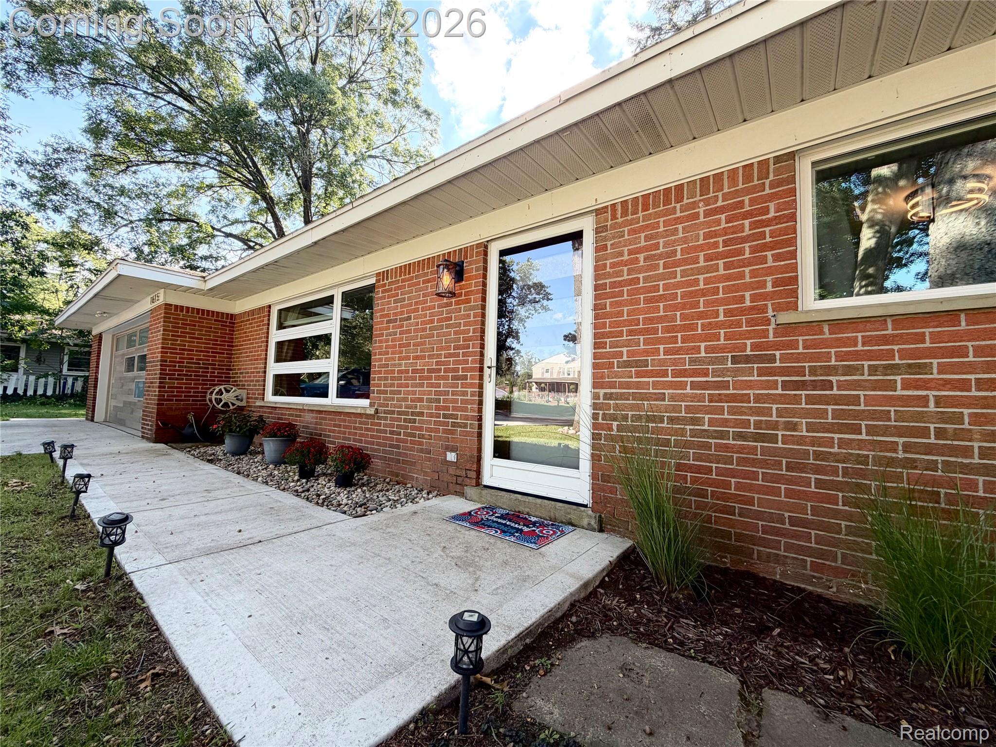 1615 Ladd Road Walled Lake, MI 48390 - Photo 2 of 28 Red brick exterior with white window frames and a glass-paneled entry door