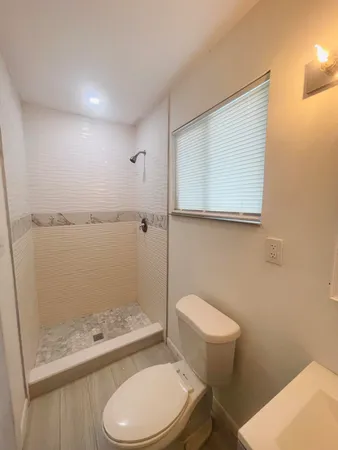 a white toilet sitting next to a bathroom sink and vanity