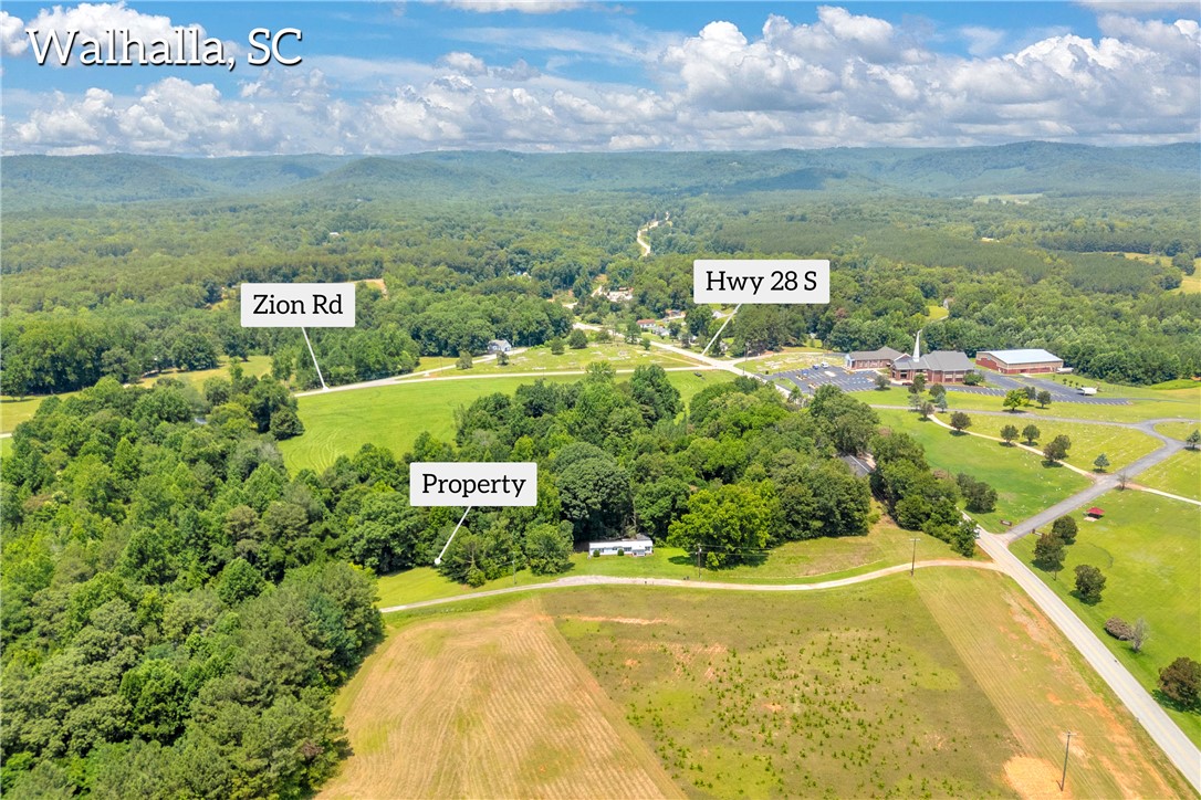 156 Newberry Road Walhalla, SC 29691 - Photo 3 of 10 An aerial perspective reveals the expansive, verdant lot nestled amidst rolling hills and lush woodland.