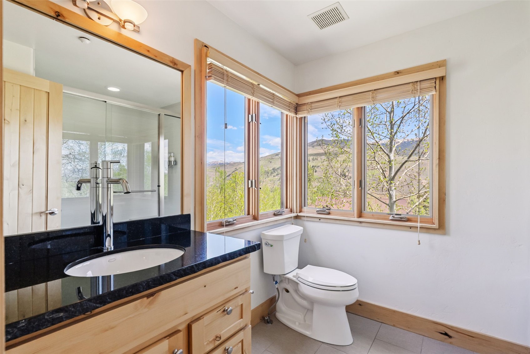2800 Hunter's Knob Road Silverthorne, CO 80498 - Photo 27 of 37 a bathroom with a granite countertop sink toilet a large mirror and a large window