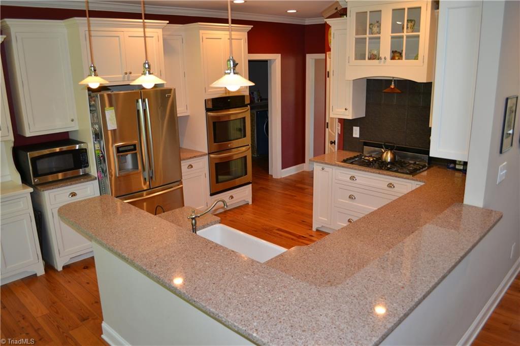 1484 Smothers Road Madison, NC 27025 - Photo 16 of 30 The warmly lit generous kitchen is a chiefs dream. The kitchen features easy to maintain Quartz counter tops, farm sink with disposal, 5 burner Kenmore Elite gas (propane) cook top, Kenmore Elite double convection ovens, the matching refrigerator is to remain. Storage is no longer a problem with generous cabinet storage, custom matching side board (attached to home), and step in pantry.