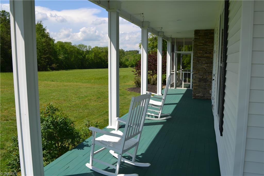 1484 Smothers Road Madison, NC 27025 - Photo 3 of 30 Wraparound porch facing the western field with private side entry and access to the screen porch.