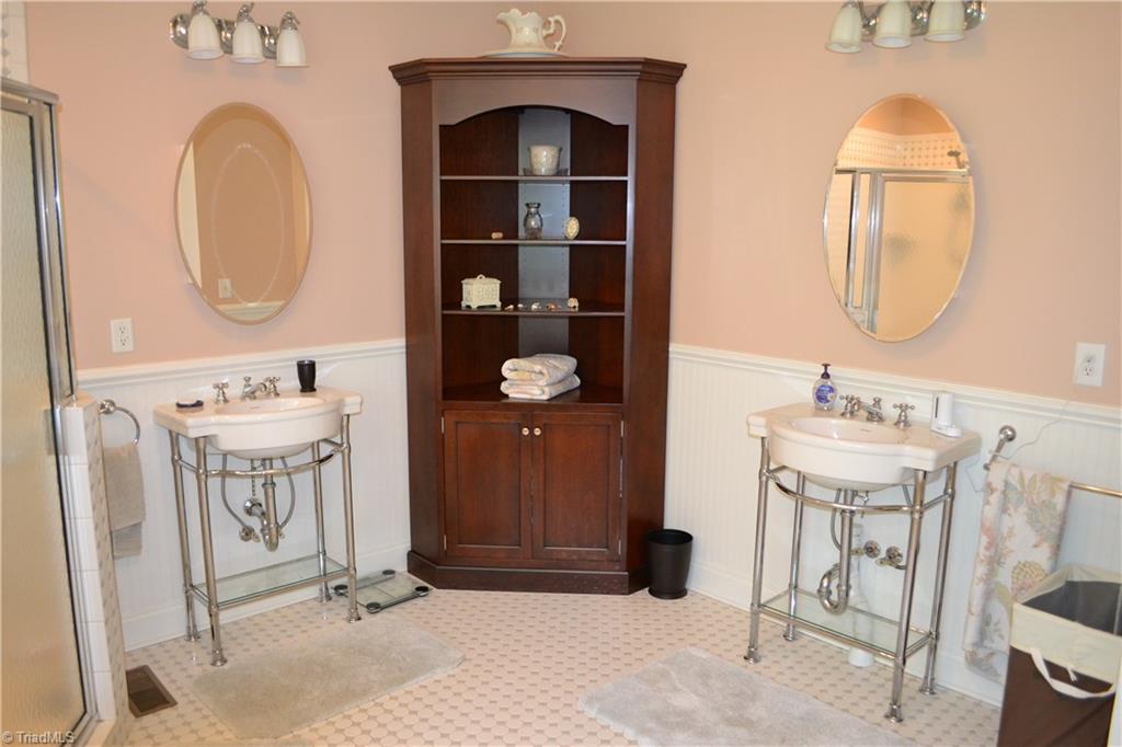 1484 Smothers Road Madison, NC 27025 - Photo 23 of 30 His and Hers sinks offer plenty of elbow room when its time to get ready in the morning. The corner cupboard shown will be conveyed with the home. The water closet is just out of view and features a private swing out door.