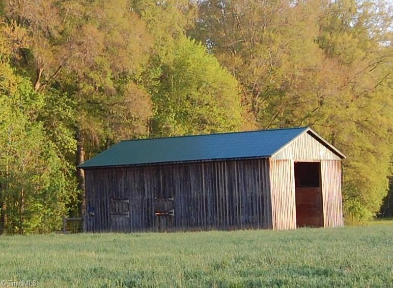 1484 Smothers Road Madison, NC 27025 - Photo 5 of 30 Front of horse barn. The barn features 2 oversized stalls plus an open area that could be enclosed to create two more stalls. Additionally there is a heated tack room with water connection, storage area and large hay loft. The barn is equipped with a 200 amps of power on a separate meter.