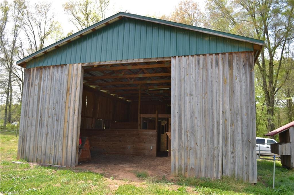 1484 Smothers Road Madison, NC 27025 - Photo 6 of 30 Barn run in, note the water spigot in between the barn and chicken coop. The barn and coop are a very short walk from the house on the other side of the trees.