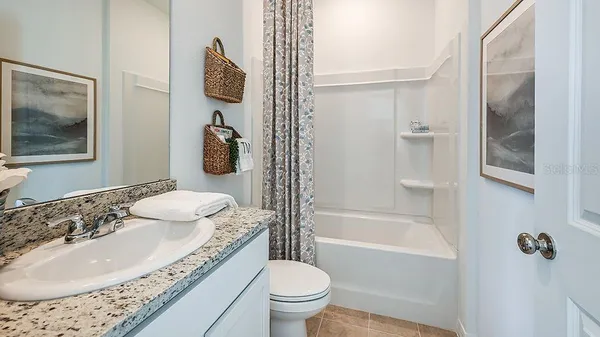 a bathroom with a granite countertop sink a toilet a mirror and shower