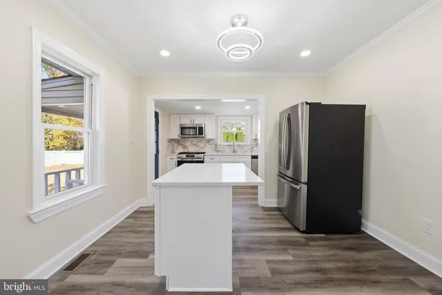 a kitchen with stainless steel appliances a refrigerator and a stove top oven