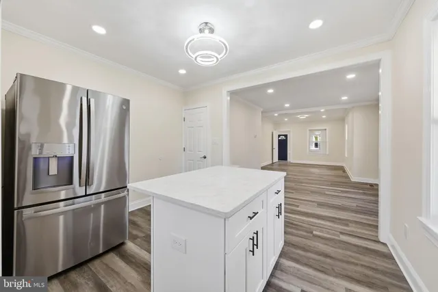 a kitchen with granite countertop a refrigerator and a stove top oven