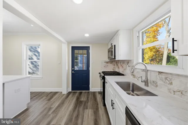 a kitchen that has a sink a stove and window