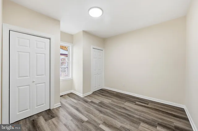 an empty room with wooden floor and closet