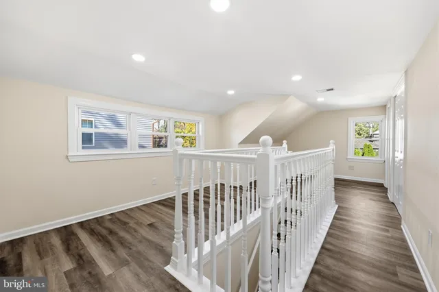 a view of a hallway with wooden floor and windows