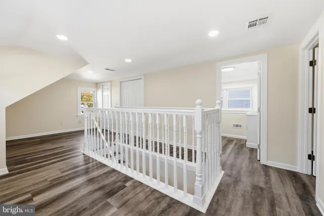 a view of a hallway with wooden floor and windows
