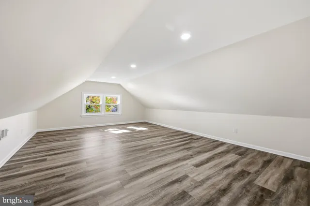 a view of empty room with window and wooden floor