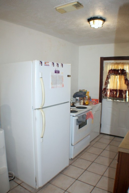 3827 Landa Lane Houston, TX 77023 - Photo 11 of 23 a white refrigerator freezer and a stove sitting inside of a kitchen