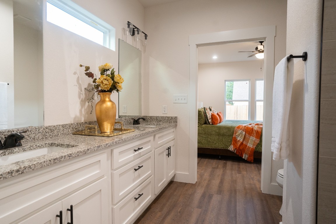 304 String Prairie Way Smithville, TX 78957 - Photo 18 of 30 Full bathroom with wood finished floors, double vanity, toilet, a ceiling fan, and connected bathroom