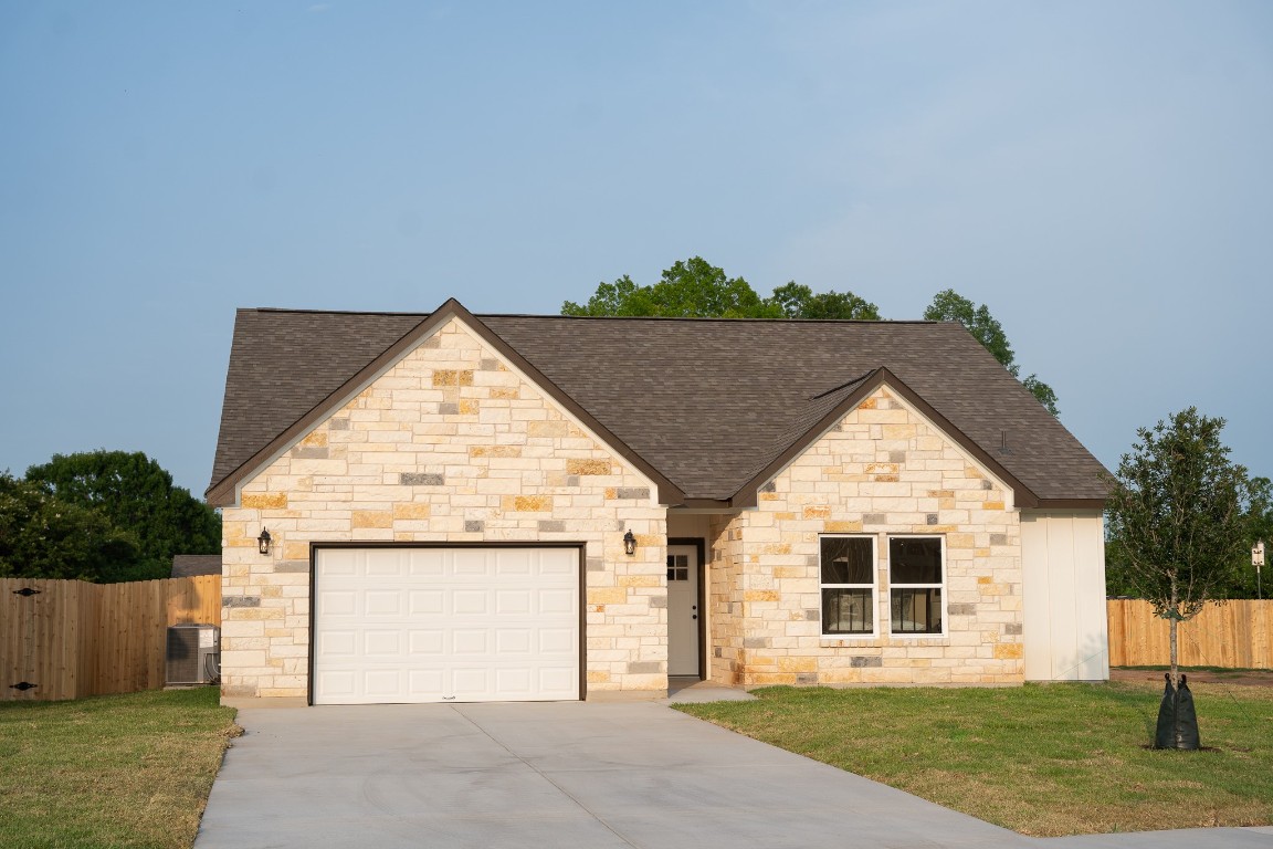 304 String Prairie Way Smithville, TX 78957 - Photo 5 of 30 French country style house with a shingled roof, concrete driveway, a garage, and stone siding