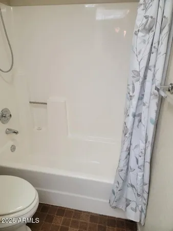 a white toilet sitting next to a bath tub and a shower