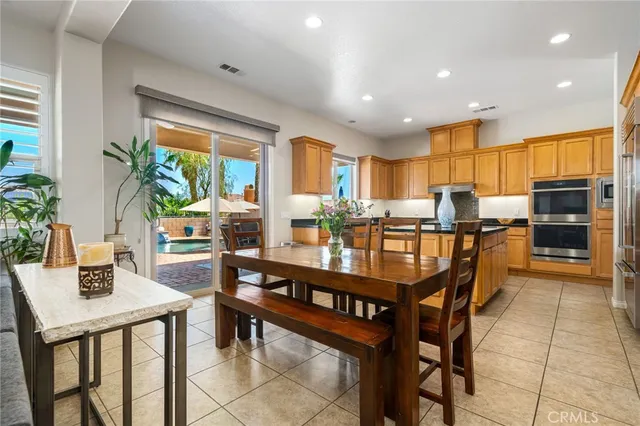 a kitchen with stainless steel appliances granite countertop a stove a refrigerator and a dining table