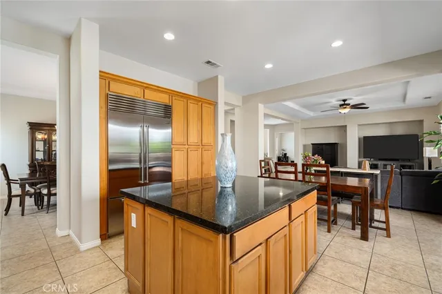 a kitchen with stainless steel appliances granite countertop a refrigerator a oven a sink a dining table and chairs