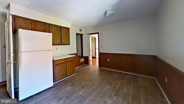 a kitchen with wooden cabinets and refrigerator