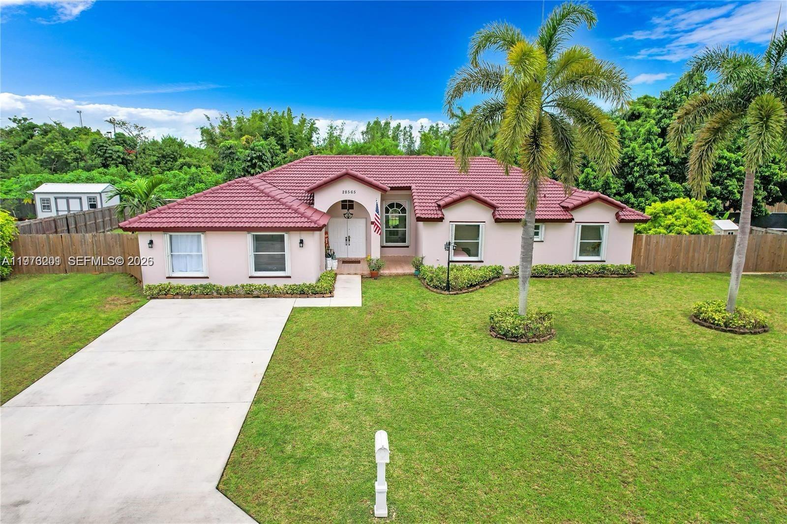 28565 Southwest 158th Court, Unit A Homestead, FL 33033 - Photo 1 of 11 a front view of a house with garden