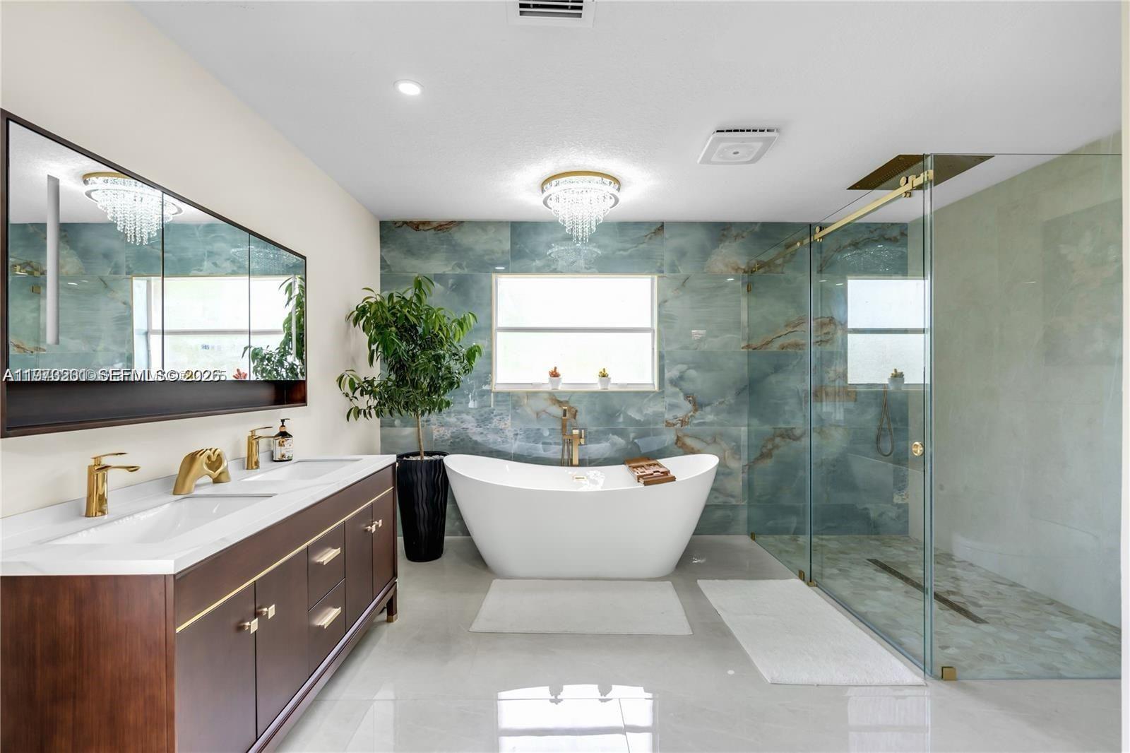 28565 Southwest 158th Court, Unit A Homestead, FL 33033 - Photo 3 of 11 a bathroom with a sink a mirror a window and a shower