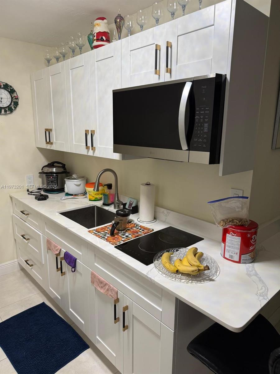 28565 Southwest 158th Court, Unit A Homestead, FL 33033 - Photo 4 of 11 a kitchen with a sink a stove and cabinets