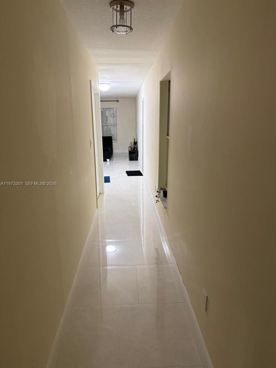 28565 Southwest 158th Court, Unit A Homestead, FL 33033 - Photo 7 of 11 a view of a hallway with a glass door and mirror