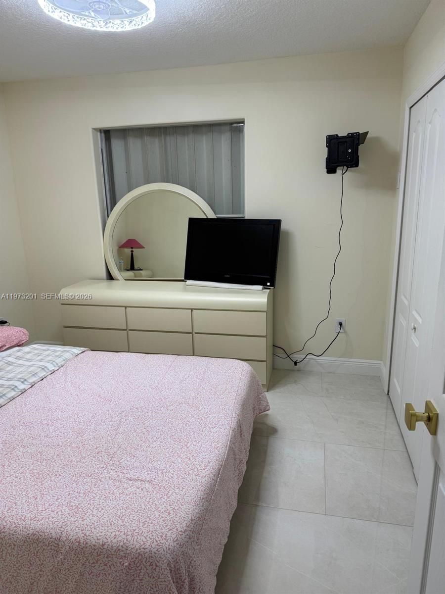 28565 Southwest 158th Court, Unit A Homestead, FL 33033 - Photo 10 of 11 a bedroom with a bed and window