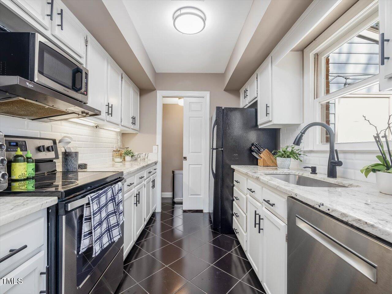 1328 Baez Street Raleigh, NC 27608 - Photo 10 of 32 a kitchen with stainless steel appliances granite countertop a sink stove and refrigerator