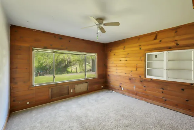 a view of a livingroom with a ceiling fan and window