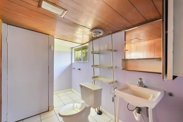 a bathroom with a toilet sink and mirror
