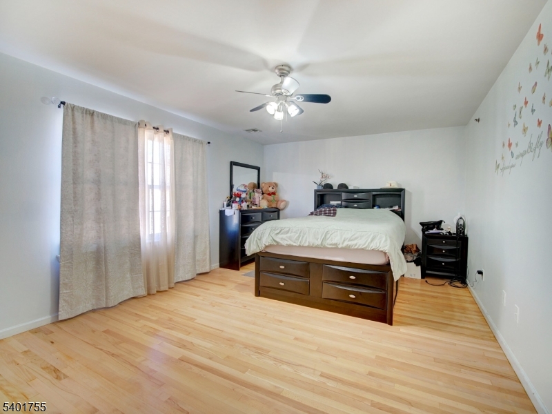 415 Loomis Street Elizabeth Port, NJ 07206 - Photo 18 of 27 a bedroom with a bed and wooden floor