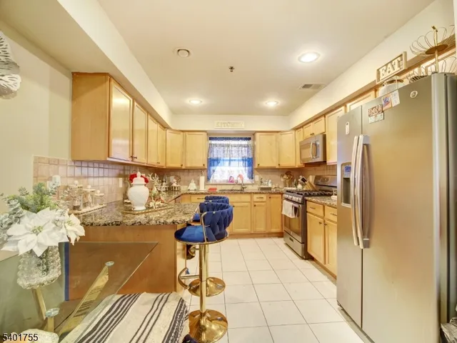 a kitchen with stainless steel appliances granite countertop a refrigerator and a stove