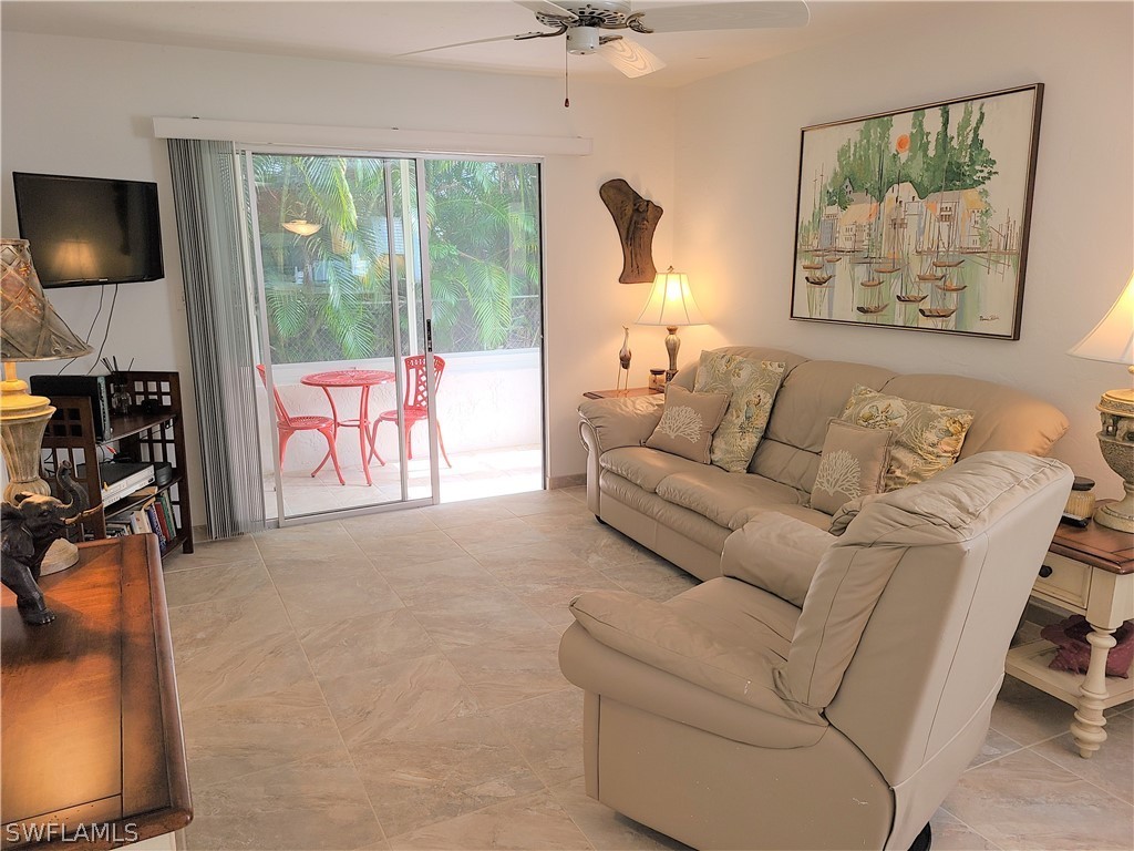 8071 Country Road, Unit 102 Fort Myers, FL 33919 - Photo 5 of 20 a living room with furniture a flat screen tv and a large window