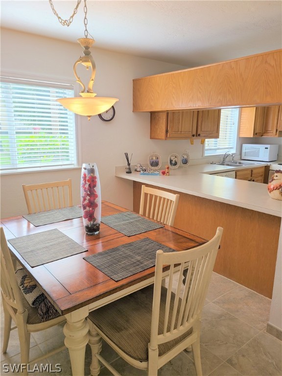 8071 Country Road, Unit 102 Fort Myers, FL 33919 - Photo 8 of 20 a kitchen with stainless steel appliances kitchen island granite countertop a table chairs in it and wooden floors