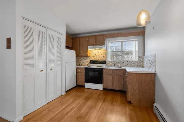 a kitchen with a refrigerator and a stove top oven