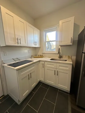 a kitchen with cabinets appliances a sink and a window